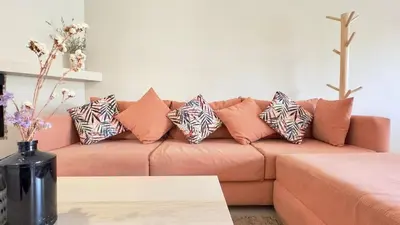 a living room with a couch with pillows on it at Villa Bella Marrakech avec piscine sans vis-à-vis 9 min du centre in Marrakech