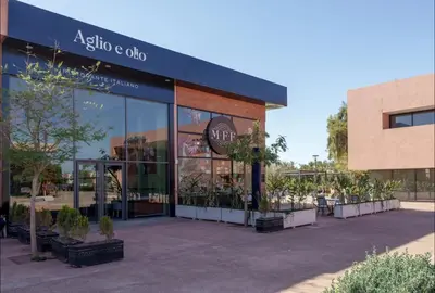 a store front of a building with potted plants at Domaine Noria - Modern apartment, quiet & 4 pools in Marrakech