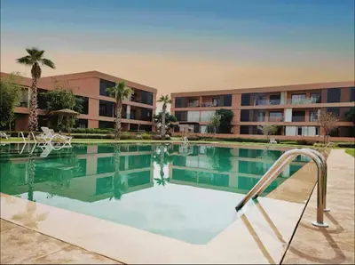 a large swimming pool in front of a building at Domaine Noria - Modern apartment, quiet & 4 pools in Marrakech
