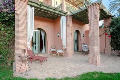 a patio with a red bench and a table at Marrakech Palmeraie 2, 2-bedroom appartment, G1 , swimming pool residence, in Marrakech