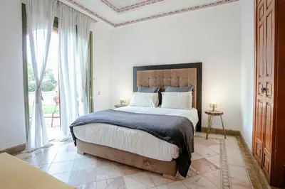 a bedroom with a large bed and a large window at Marrakech Palmeraie 2, 2-bedroom appartment, G1 , swimming pool residence, in Marrakech