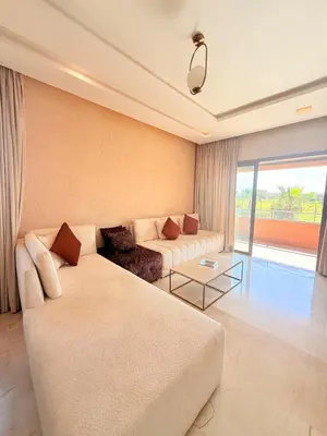 a living room with a couch and a table at Appartement Confortable Vus Sur Piscine A Prestigia in Marrakech