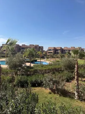 a resort with a pool and palm trees and buildings at Appartement Confortable Vus Sur Piscine A Prestigia in Marrakech
