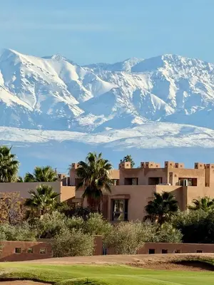a house in front of a mountain with snow at Appartement Confortable Vus Sur Piscine A Prestigia in Marrakech