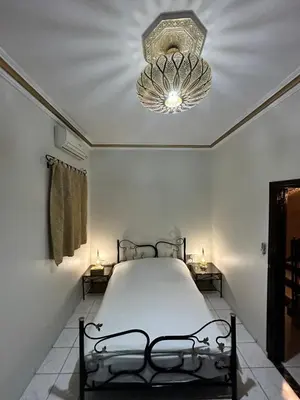 a bedroom with a bed and a chandelier at Riyad Ambre in Marrakech