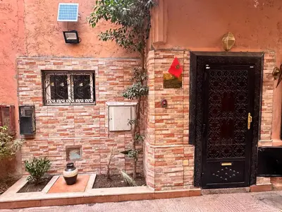 a brick building with a black door and a window at Riyad Ambre in Marrakech