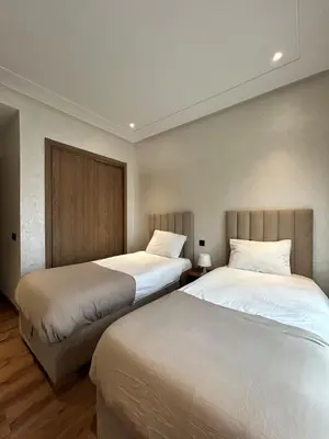 two beds in a hotel room with white sheets at Appartement Moderne - Accès Piscines et Fitness in Marrakech