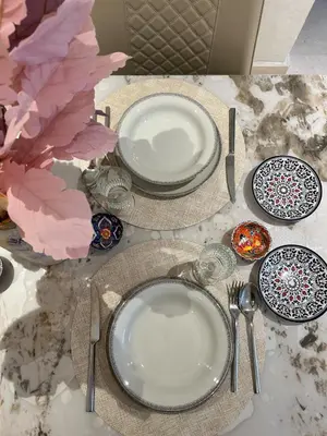 a table with plates and utensils on a table at Appartement Moderne - Accès Piscines et Fitness in Marrakech