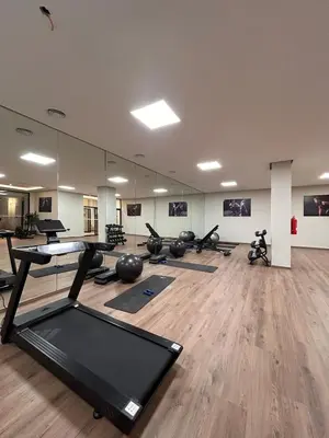 a gym with a lot of exercise equipment in a room at Appartement Moderne - Accès Piscines et Fitness in Marrakech