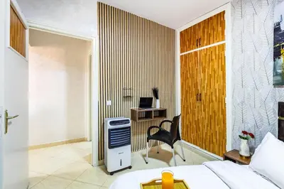 a bedroom with a bed and a desk and a chair at Stylish Apartment in Gueliz by Train And Majorelle in Marrakech