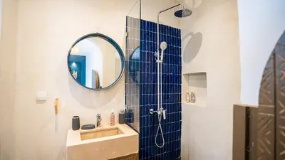 a bathroom with a shower with a mirror and a sink at Riad Alaya by Maison Amellal in Marrakech