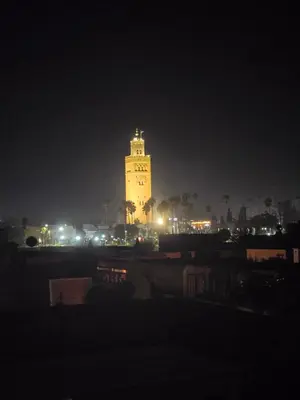 a large clock tower at night with lights at Riad Alaya by Maison Amellal in Marrakech