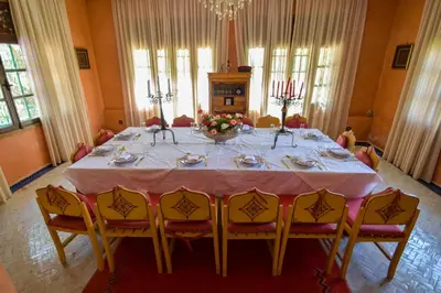 a dining room with a table with yellow chairs at Bluegreen Guest House Marrakech in Aït Amara