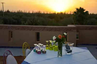 a table with a vase of flowers on top of it at Bluegreen Guest House Marrakech in Aït Amara