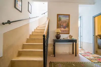 a staircase in a home with a table at Riad privé 3 chambres, pdj inclus, 10 min Jema El Fna in Marrakech