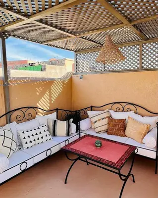 a porch with a couch and a table on a patio at Riad privé 3 chambres, pdj inclus, 10 min Jema El Fna in Marrakech