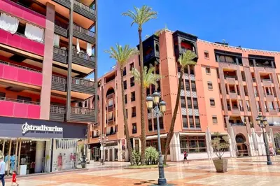a large building with palm trees in front of it at 2 bedroom apartment in Plaza central Gueliz in Marrakech