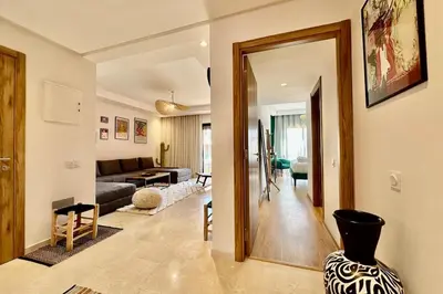 a living room with a couch and a vase at Domaine de Noria with terrace and Pools in Marrakech