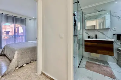 a bedroom with a bed and a bathroom with a shower at Atlas Golf Resort with Terrace and Pools in Marrakech