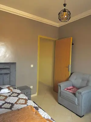 a bedroom with a bed and a couch and a chair at Modern Apt 10min Airport Balcony & Wi-Fi in Marrakech