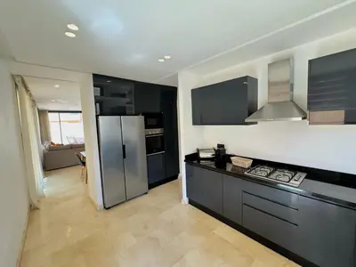a kitchen with black cabinets and a stainless steel refrigerator at Villa terracotta in Marrakech