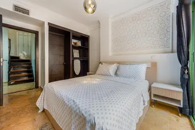 a bedroom with a white bed and a staircase at Majorelle Place in Marrakech