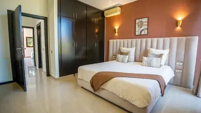 a bedroom with a large bed and a bathroom at Appart calme & central, piscine, proche médina et place Jemaa El Fna in Marrakech