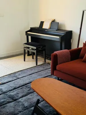 a living room with a piano and a red couch at Designer apartment with south-facing terrace in Marrakech