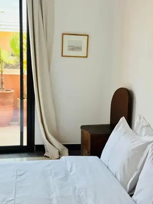 a bedroom with a bed and a sliding glass door at Designer apartment with south-facing terrace in Marrakech
