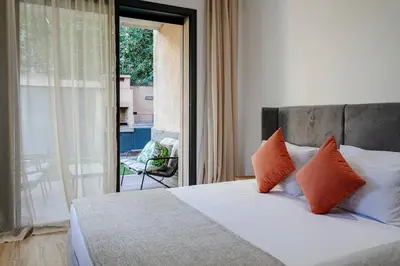 a bedroom with a bed with orange pillows and a balcony at Villa Nerolia - Marrakech in Marrakech
