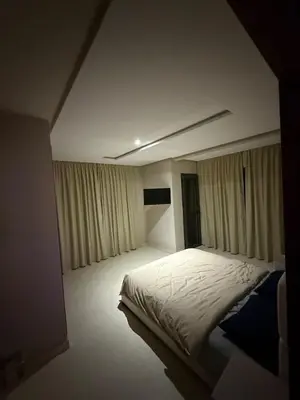 a bedroom with a large white bed with curtains at Appartement Marrakech route de casa in Marrakech
