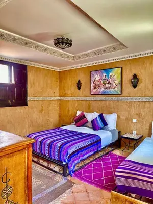 a bedroom with two beds with purple sheets at Riad alwafa B&B in Marrakech