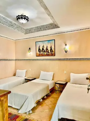 a room with two beds and a painting on the wall at Riad alwafa B&B in Marrakech
