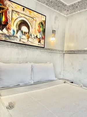 a bed in a room with a painting on the wall at Riad alwafa B&B in Marrakech