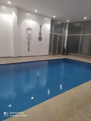 a swimming pool in a building with a blue pool at Marrakech Apartment with Pool in Marrakech