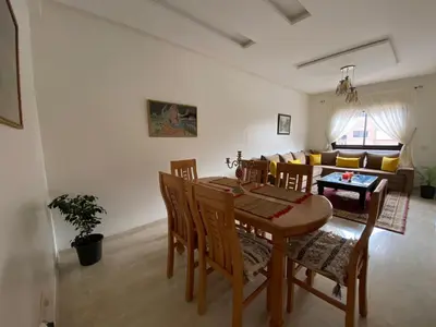 a dining room and living room with a table and chairs at Marrakech Apartment with Pool in Marrakech