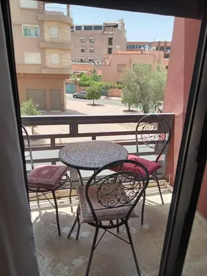 a table and chairs on a balcony with a view at Marrakech Apartment with Pool in Marrakech