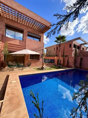 a swimming pool in front of a house at Villa Akenza Marrakech in Marrakech