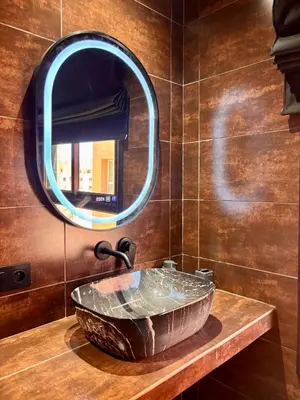 a bathroom with a large stone sink and a mirror at Cozy Urban Haut Standing au cœur de Guéliz in Marrakech