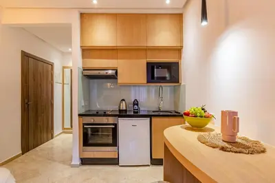 a kitchen with wooden cabinets and a counter top at Central 1BR Studio- AC & IpTV-Self check in- 2 guests in Marrakech