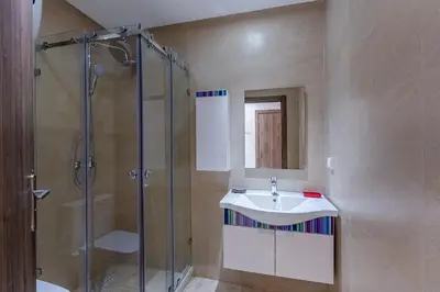 a bathroom with a glass shower and a sink at Central 1BR Studio- AC & IpTV-Self check in- 2 guests in Marrakech