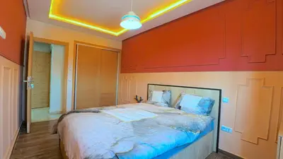 a bedroom with a large bed with an orange wall at דירה