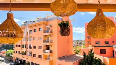 a view of a building from a balcony with hanging baskets at Beautiful Bright Apartment Victor Hugo District in Marrakech