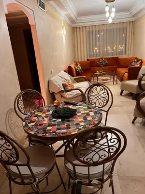 a living room with a table and chairs and a couch at App RIAD JAWHARA in Marrakech