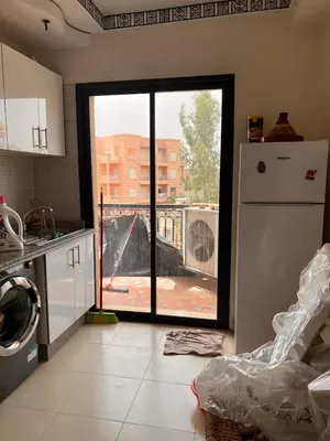 a kitchen with a refrigerator and a view of a building at App RIAD JAWHARA in Marrakech