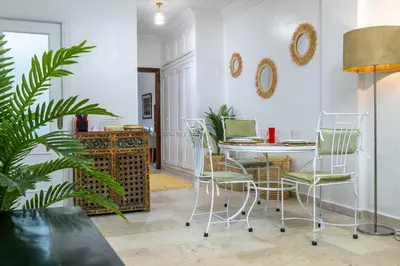 a living room with a table and chairs and a plant at Appartement de charme à Gueliz - Centre Marrakech in Marrakech