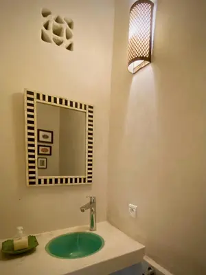 a bathroom with a green sink and a mirror at Riad Dar Bou Seta - Small Riad in Marrakech