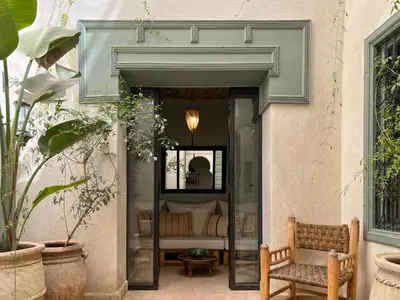 a patio with a bench and a bed in a room at Riad Dar Bou Seta - Small Riad in Marrakech