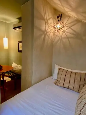 a bedroom with a white bed and a chandelier at Riad Dar Bou Seta - Small Riad in Marrakech
