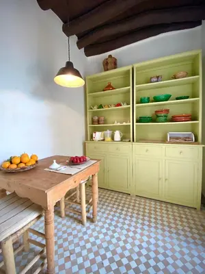 a kitchen with a wooden table and green cabinets at Riad Dar Bou Seta - Small Riad in Marrakech